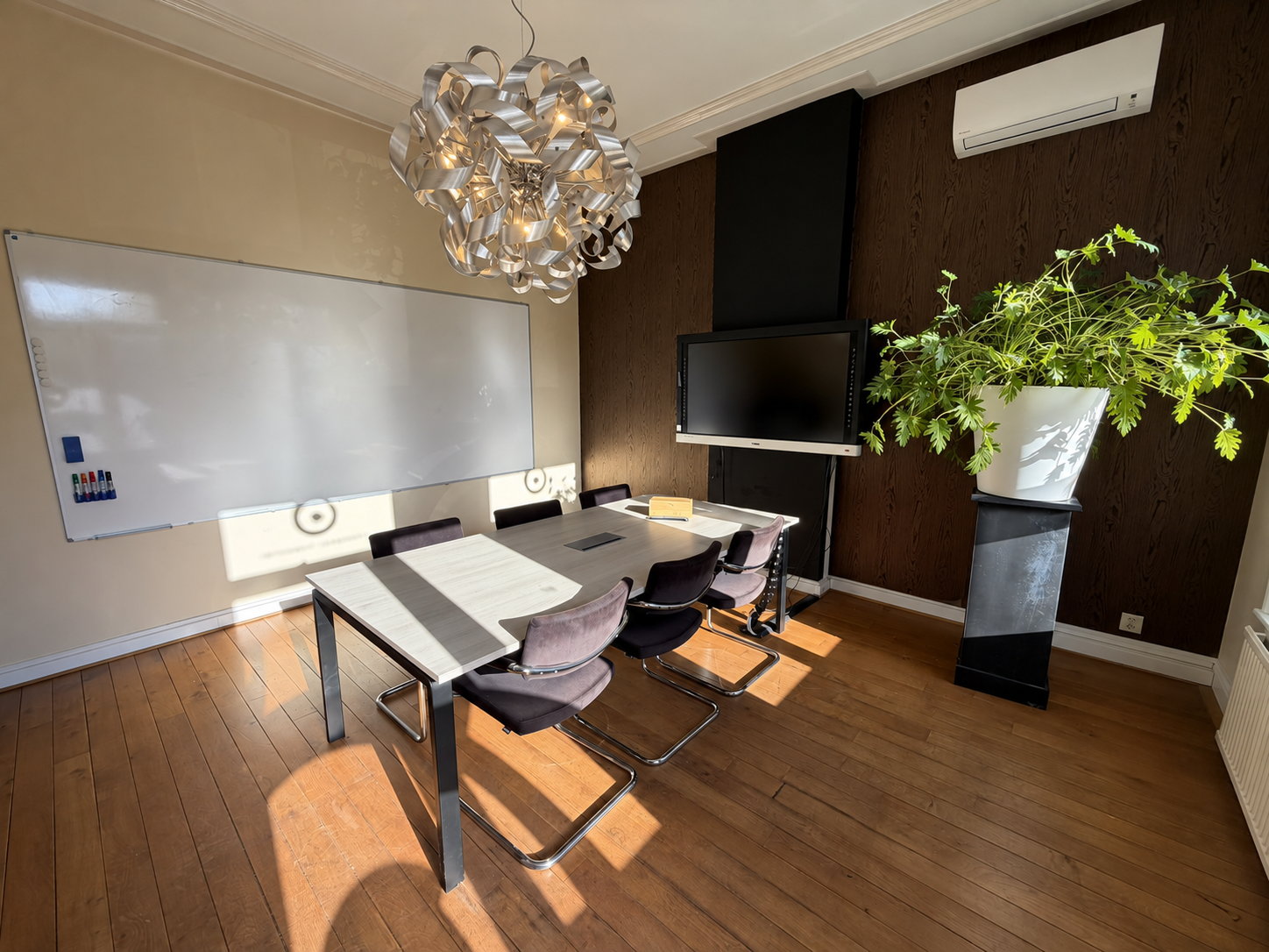 Vergaderruimte met groot whiteboard, touchscreen en verlichte hanglamp